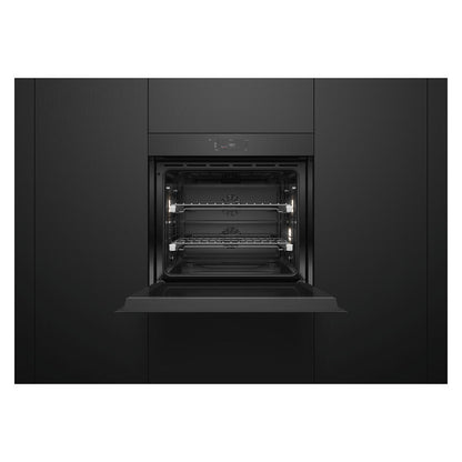 A built-in wall oven with its door open, showing the interior racks and light elements, set within a dark charcoal kitchen cabinet.