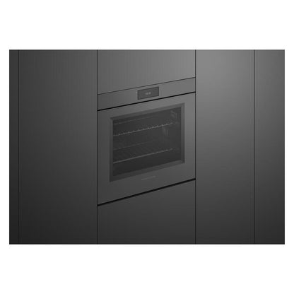 A built-in electric oven with a glass door and digital control panel, integrated into dark charcoal kitchen cabinets.