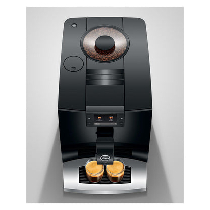 A sleek black coffee machine with a transparent bean hopper showing coffee beans, two espresso cups filled with espresso and milk at the dispensing tray, and a small circular logo badge, set against a light gray background.
