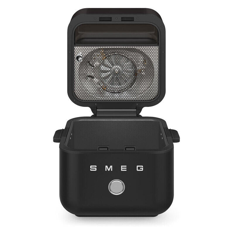 A black SMEG countertop air fryer with its lid open, showing the interior fan and mesh filter, on a clean white background.
