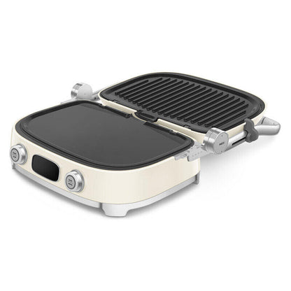 A compact electric grill with a cream-colored body, silver metal accents, and black non-stick plates, shown open on a white background.