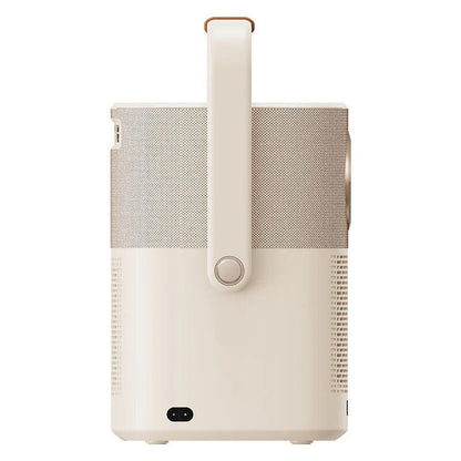 A portable projector or speaker with a beige and white color scheme, featuring a textured mesh front, a vertical handle, and a circular control button.